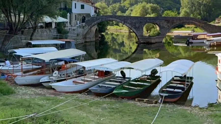 Boats moored by the old stone bridge in Rijeka Crnojevića